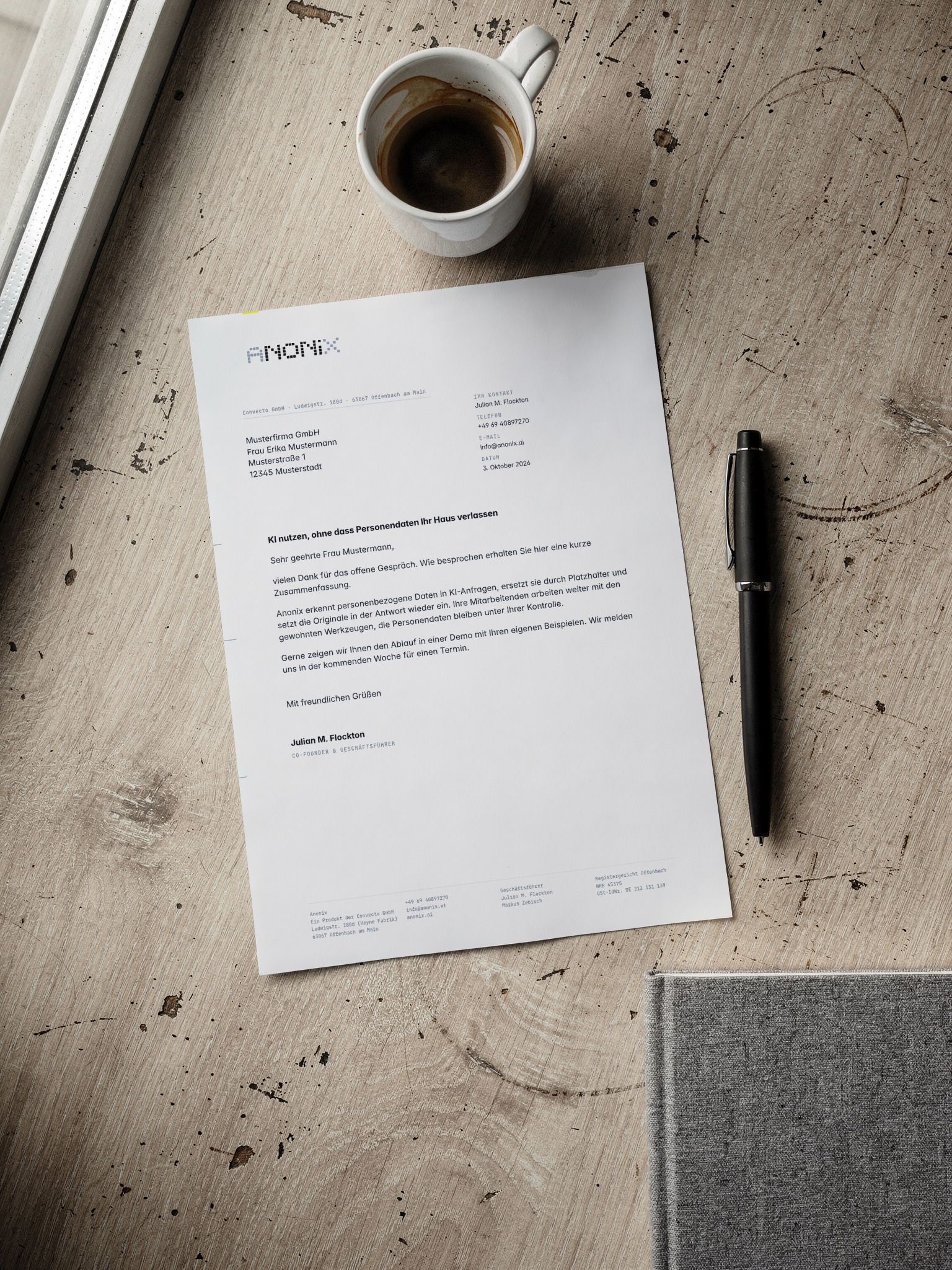 Anonix letterhead on a light wooden table, next to a cup of coffee and a black fountain pen