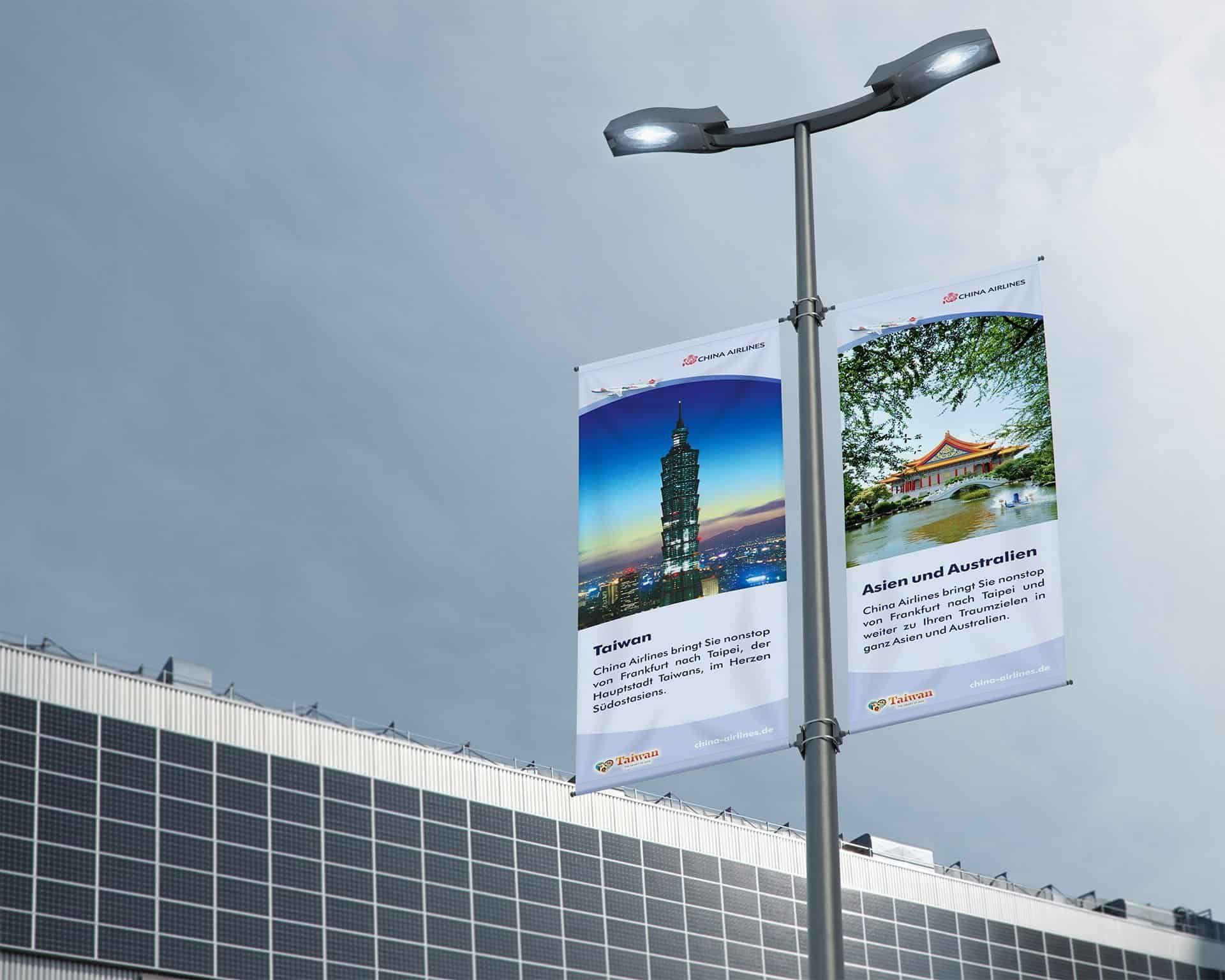 Two China Airlines street banners on a lamp post: Taiwan with the Taipei 101 tower, and Asia and Australia with a pavilion by the water